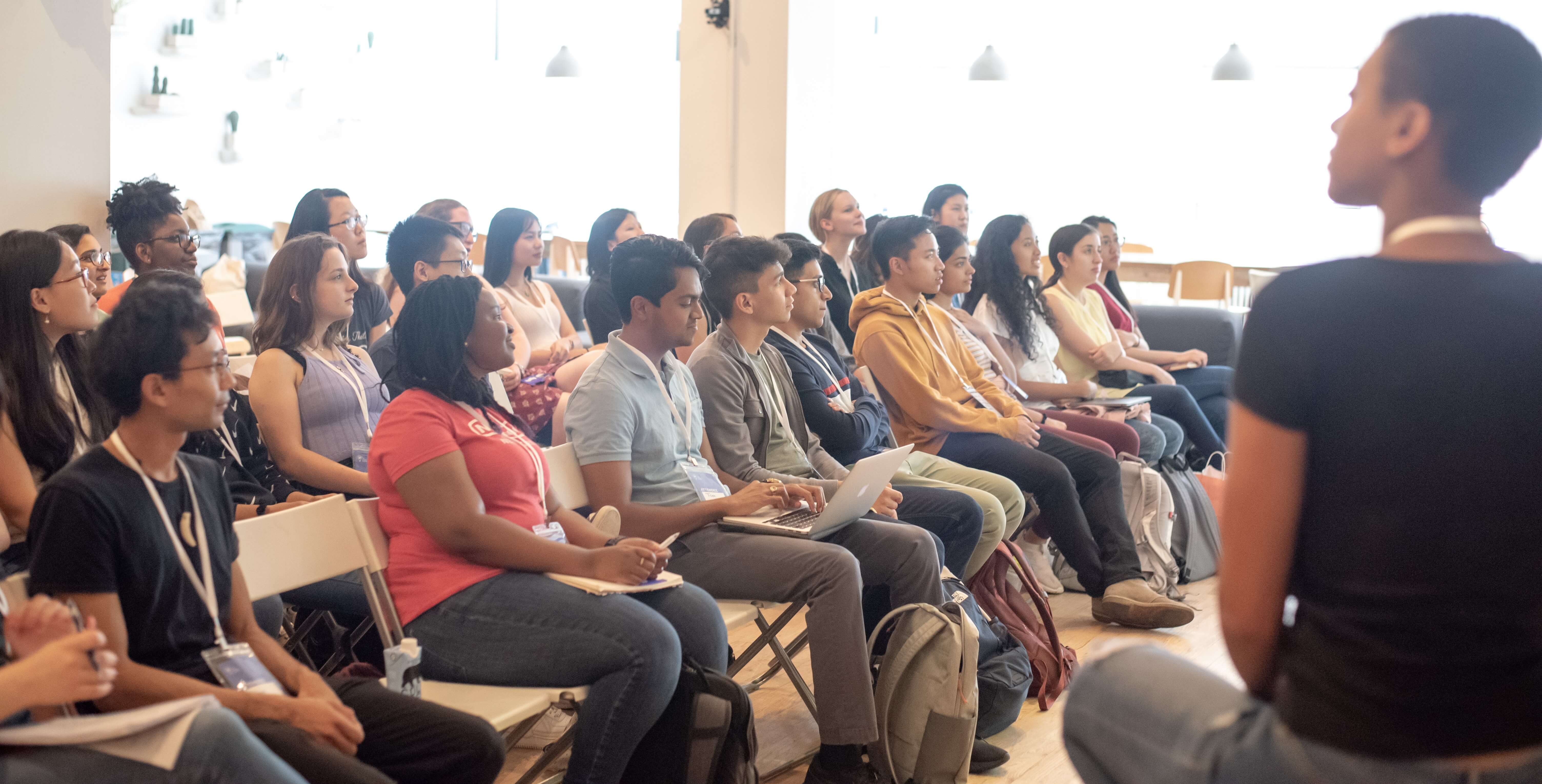 Audience listening to speaker at impact summit